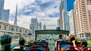 Passengers delight in Dubai's vibrant cityscape and lively street view from the Hop-on Hop-off bus, immersing themselves in its beauty.